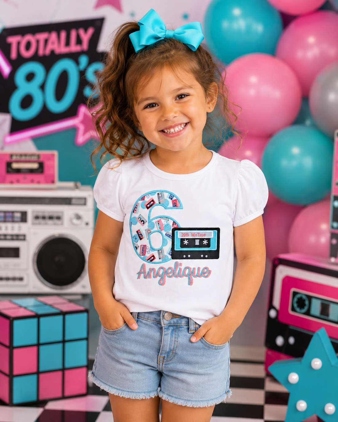 Personalized embroidered girl's 80's birthday shirt featuring a retro cassette tape, embroidered number 6, and custom name Angelique on a white 100% cotton birthday shirt by RoJo Custom Designs.