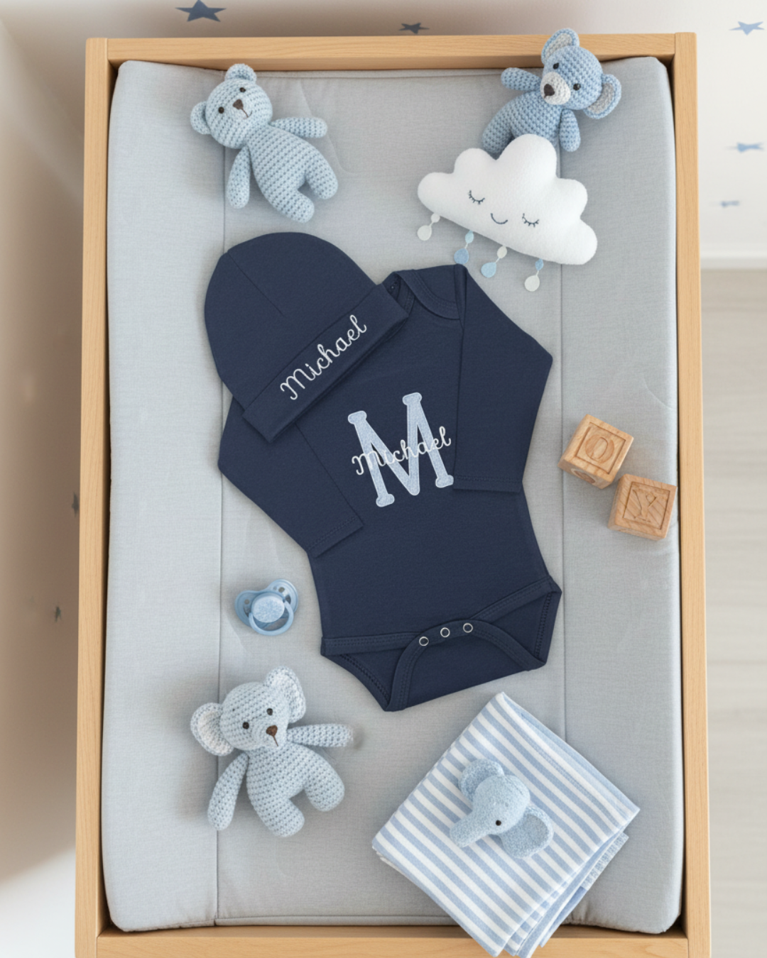 Baby gift set with navy blue onesie, hat, and toys in a wooden box.