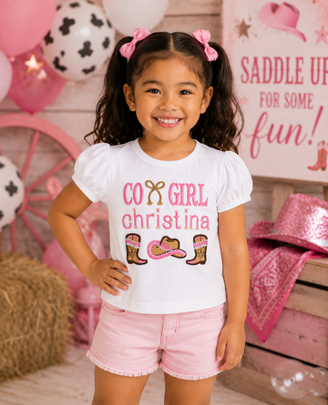 Girl wearing a personalized embroidered cowgirl birthday shirt featuring western boots, cowboy hat, rope detail, and custom embroidered name at a western birthday party by RoJo Custom Designs.