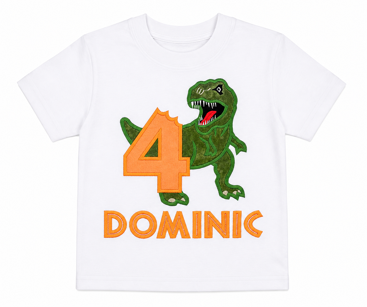 Lay-flat view of a personalized embroidered dinosaur birthday shirt featuring a green T-Rex, orange number 2, and custom embroidered name Lucas on a white 100% cotton shirt. | RoJo Custom Designs