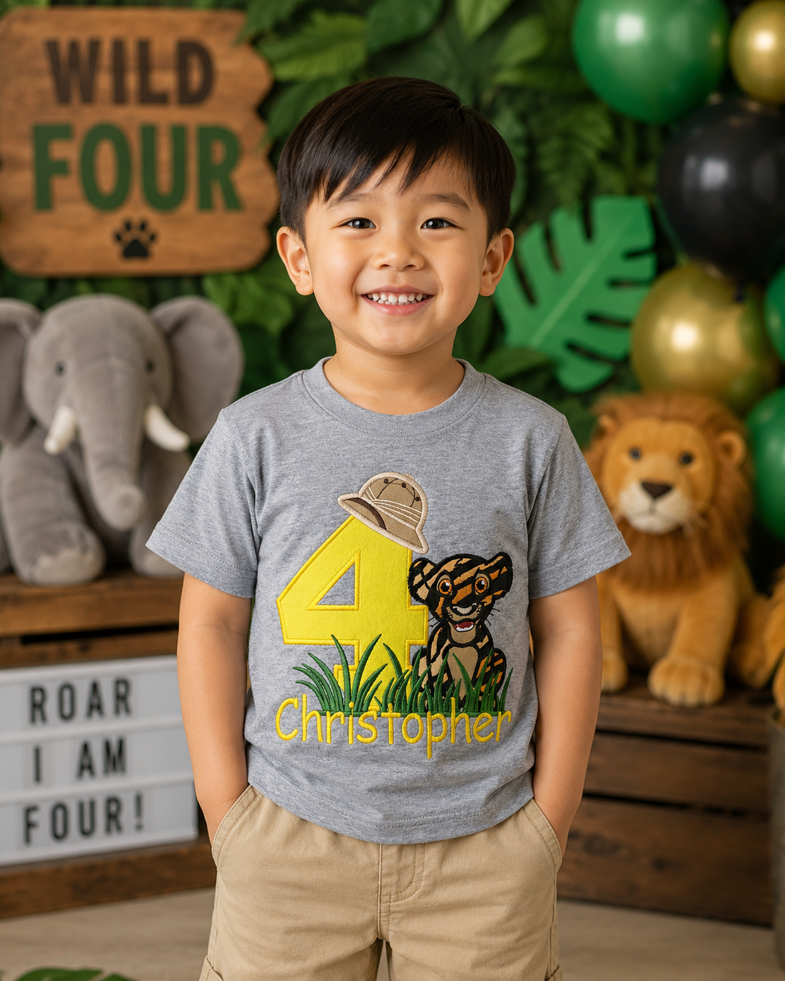Personalized embroidered safari birthday shirt for boys featuring a yellow number 4, adorable tiger cub, safari explorer hat, and custom embroidered name Christopher on a gray 100% cotton shirt at a safari-themed birthday party. | RoJo Custom Designs