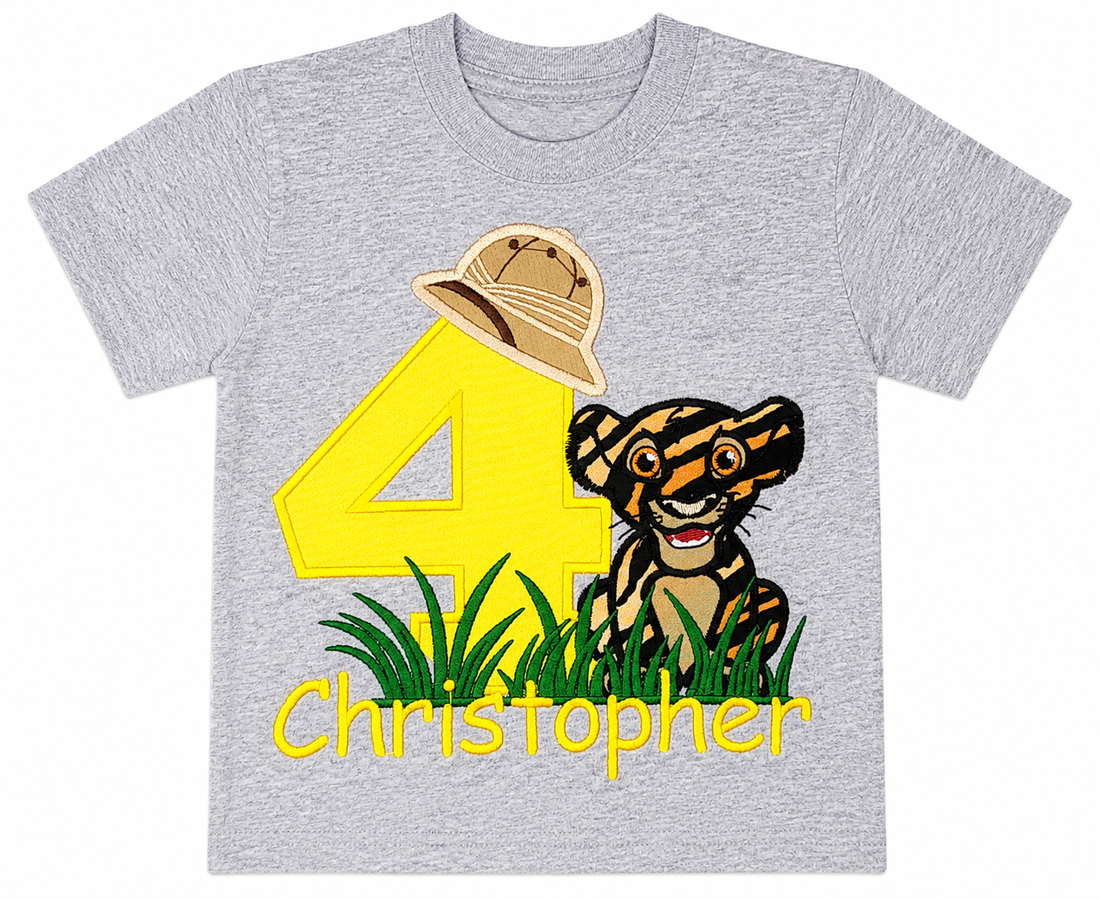 Personalized embroidered safari birthday shirt for boys featuring a yellow number 4, adorable tiger cub, safari explorer hat, and custom embroidered name Christopher on a gray 100% cotton shirt at a safari-themed birthday party. | RoJo Custom Designs